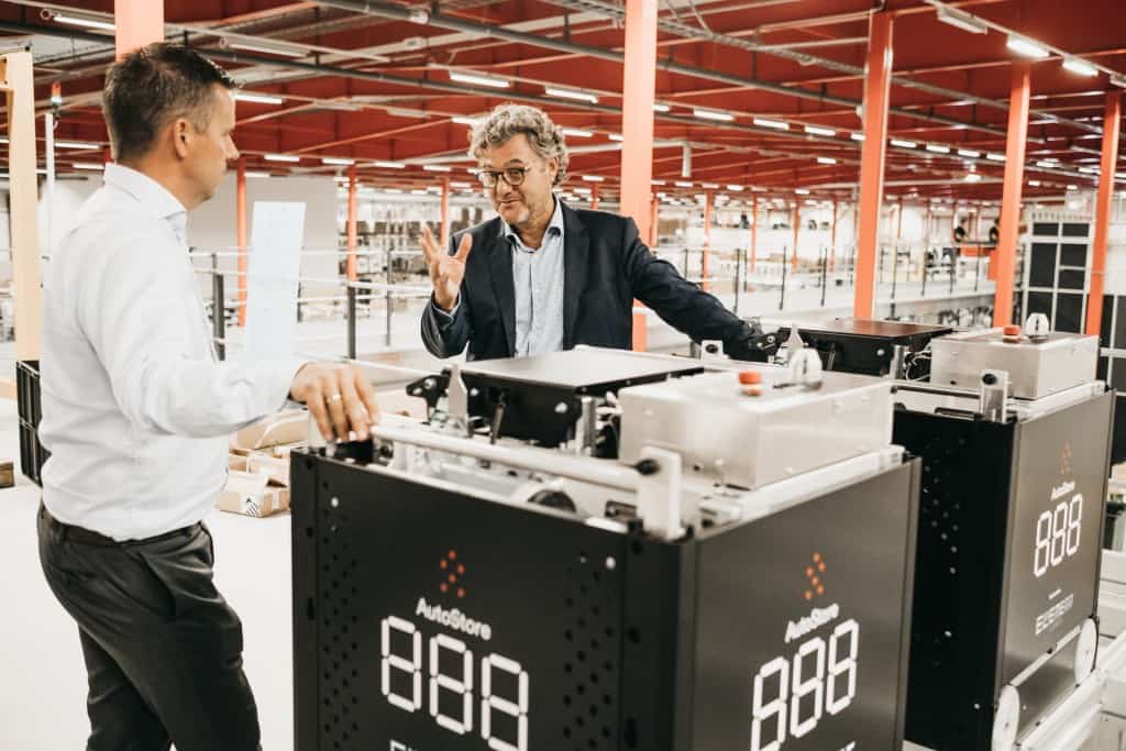 Niels Hemmingsen von Boozt diskutiert mit Havard Hallas von Element Logic an einem Black Line AutoStore Roboter